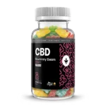 Egy átlátszó üveg színes CBD Izolátum & C-vitaminos gumicukor - 1500mg | 75db, vegán és Happy Garden márkajelzéssel fekete és rózsaszín címkén - ideális azok számára, akik prémium CBD olajat keresnek.