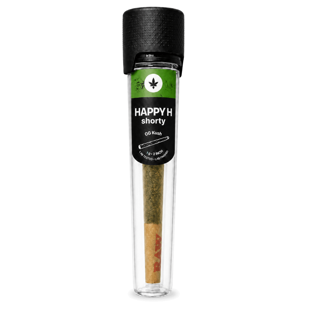 Egy 1 g-os, „Happy H Shorty – OG Kush | CBDX Enriched Pre-Roll” feliratú, előre sodort jointot egy fekete kupakos, átlátszó műanyag csőbe csomagoltak. A címkén egy kannabiszlevél-ikon és az adagolási adatok láthatók, a joint papírján pedig a RAW márkajelzés is felismerhető.