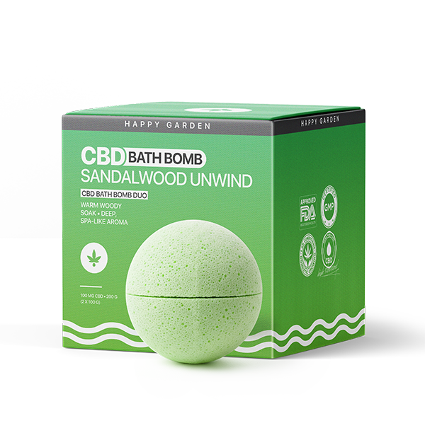 A zöld CBD fürdőbomba egy zöld-fehér dobozban látható, amelyen a Sandalwood Unwind - CBD Fürdőbomba Duo - 100mg CBD felirat szerepel, kiemelve a fás, gyógyfürdő-szerű illatokat és a Happy Garden tanúsító ikonjait.