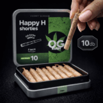 Egy kéz tart egy kis prerollt egy nyitott konzervdoboz felett, amelyen a Happy H Shorties - Pineapple Express | CBDX Enriched Pre-Rolls - 10db felirat szerepel. A doboz több jointot tartalmaz, és egy kannabiszlevél grafikát ábrázol.
