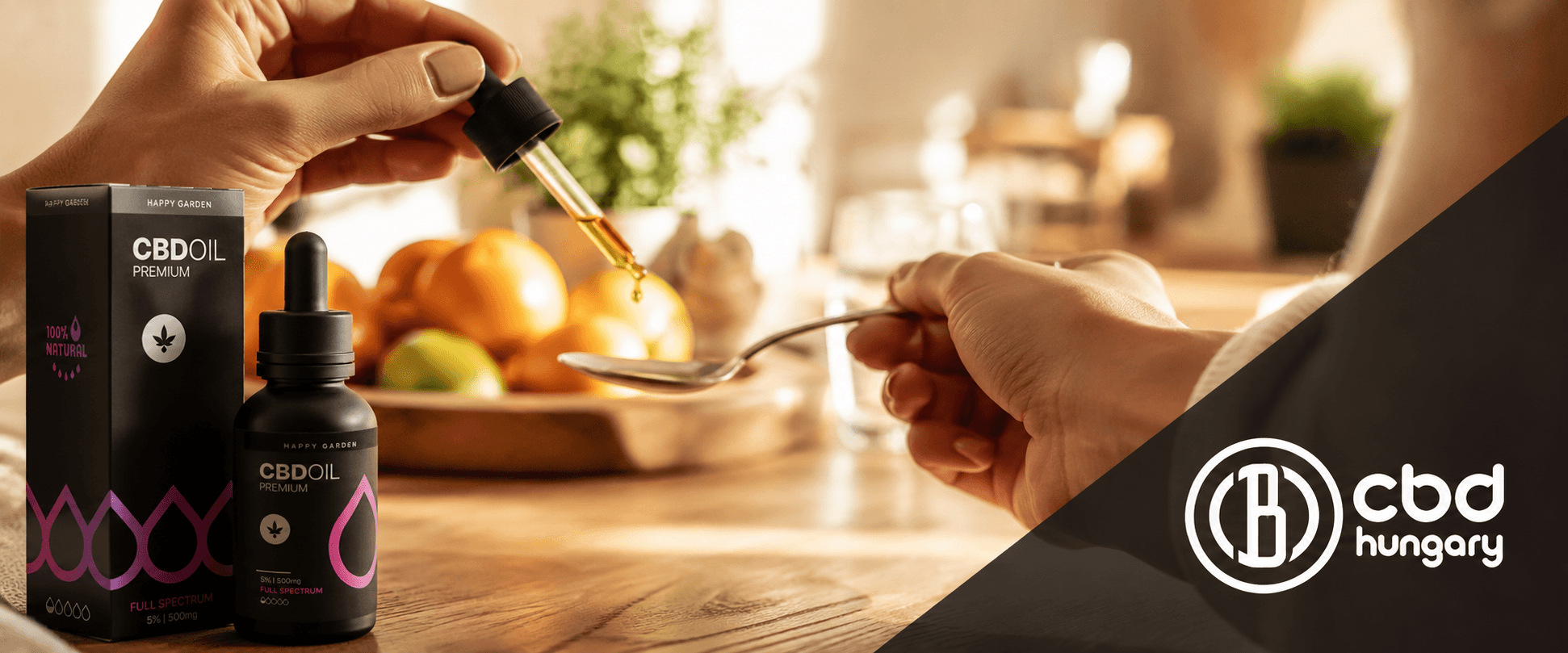 Egy kéz egy CBD-olajjal töltött cseppentőt tart, és abból egy kanálra csepegtet. Az asztalon egy CBD-olajos üveg és egy „CBD OIL Premium” feliratú doboz látható. A képen a „CBD Europe” logó is látható.