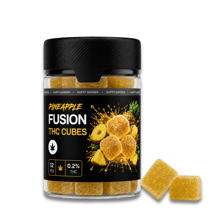 Egy „Happy H Gummies Pineapple (Ananász) – 10 mg / db – Strong Edition, 12 db” felirattal ellátott átlátszó üvegben sárga, cukorral bevont kockák találhatók. A címkén ananászszeletek és kannabiszlevelek láthatók, az üveg mellett pedig két gumi cukorka helyezkedik el.