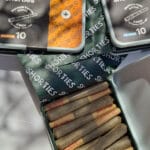 A Shorties feliratú nyitott dobozból előrenyomott, prémium minőségű, teljes spektrumú CBD-olajjal ellátott jointok kerülnek elő. A közelben a napfény egy Pineapple Express - CBD virágok 10g | Sativa és egy Blueberry Haze Sativa konzervdobozt emel ki.